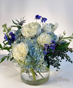 a vase filled with white and blue flowers