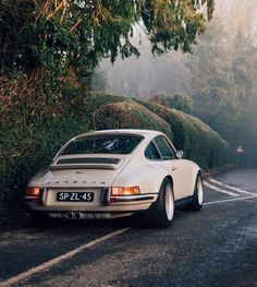 a white porsche parked on the side of a road