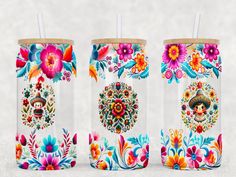 three colorful tumblers with straws on top of each one are decorated with flowers