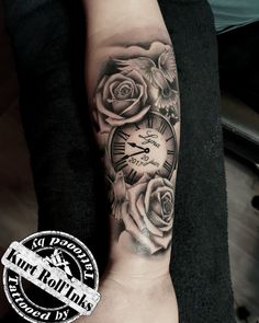 a person with a tattoo on their arm holding a clock and roses in the background