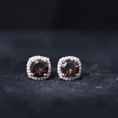 Product Details Shine bright with these stud earrings that feature a round-cut smoky quartz solitaire surrounded by a halo of Diamond gems, making them a one-of-a-kind piece. Product Information SKU SHP-EARRINGS052174928 Weight 1.25 gm (Approximate) SMOKY QUARTZ INFORMATION No.of Stones 2 Pieces Total Weight 1.60 Carat (Approximate) Dimension(approx) Round-6X6 mm-2 Pcs Color Brown Cut Brilliant Shape Round Setting Type Prong-Setting Quality Grade AAA DIAMOND INFORMATION No.of Stones 48 Pieces To Smoky Quartz Earrings, Quartz Earrings, Diamond Halo, Smoky Quartz, Shine Bright, Halo Diamond, Prong Setting, Halo, Gems