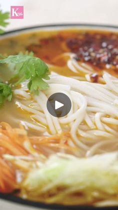 a bowl of soup with noodles, carrots and parsley on the side is shown