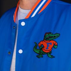 To create this vintage-inspired bomber jacket with varsity vibes, we took this retro Gators logo used from 1955-1994 and paired it with the famous script “Gators” we all know and love. Brought to you in partnership with College Vault. Collegiate Varsity Jacket With Logo Patch For College, College Varsity Jacket With Logo Patch, Collegiate Varsity Jacket With Embroidered Patch For College, Retro Varsity Jacket With Letter Patch, Throwback Varsity Jacket For Game Day, Retro Varsity Jacket With Embroidered Patch For Streetwear, Retro Varsity Jacket With Embroidered Logo, Retro Varsity Jacket For Baseball Season, Throwback Varsity Jacket For Baseball Season