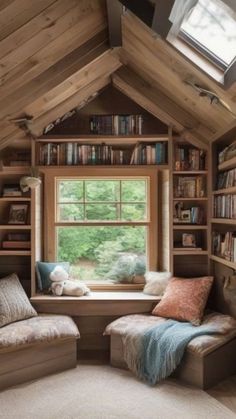 a window seat in front of a book shelf filled with books