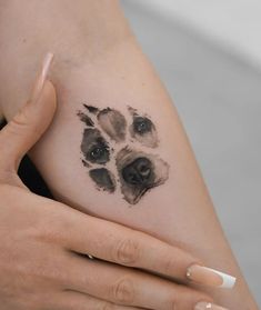 a woman's arm with a dog paw tattoo on the left side of her body