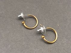 Gold plated Mini Creole Earrings. The hoop is 1cm diameter. The earrings are made from brass, and the posts are sterling silver. ------------------------------------------ You may also be interested in -  Our Recycled Glass and Gold Circle Earrings:  https://www.etsy.com/uk/listing/524538124/green-recycled-glass-gold-hoop-drop?ref=shop_home_active_4 Our Malachite and Gold Circle Earrings:  Our Recycled Glass Ball Pendant:  https://www.etsy.com/uk/listing/523202258/recycled-glass-ball-pendant-nec Adjustable Gold Plug Earrings With Ear Wire, Hypoallergenic Small Hoop Gold Plug Earrings, Nickel-free Small Hoop Clip-on Earrings, Gold Round Plug Earrings For Everyday, Small Hoop Gold Cartilage Earrings As Gift, Gold Small Hoop Wrap Earrings For Everyday Use, Nickel-free Gold Brass Huggie Earrings, Small Hoop Brass Cartilage Earrings, Gold Small Hoop Plug Earrings For Everyday