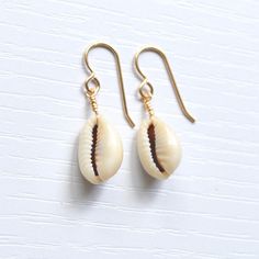 Simple & cute describe these whole cowrie shell earrings! They're the perfect accessory to wear with your favorite casual outfit when you're out & about. Please allow for variations in size and shape of shells as each is unique. Trendy Shell-shaped Jewelry Gift, Casual Shell Jewelry Gift, Handmade Cowrie Shell Earrings For Gift, Handmade Cowrie Shell Earrings As Gift, Summer Gift Shell-shaped Earrings, Cowrie Shell Dangle Jewelry For Gifts, Cowrie Shell Dangle Jewelry Gift, Gold Cowrie Shell Earrings As Gift, Gold Cowrie Shell Earrings For Gift