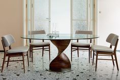 a glass table with chairs around it in the middle of a tiled floored room