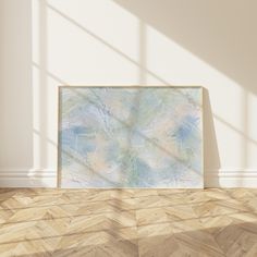 an empty room with a painting on the wall and wood flooring in front of it