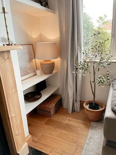 a living room with a couch, table and lamp next to a large open window