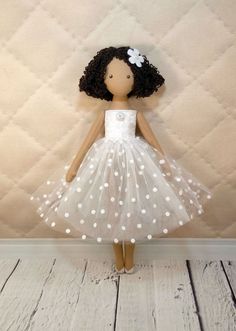 a doll is wearing a white dress with polka dots