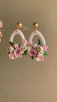 two pairs of earrings with flowers hanging from hooks