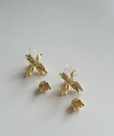 Crafted with meticulous attention to detail, each pair is made of fine copper with gold or silver plating. With a total length of approximately 8.5 centimeters, a golden flower adorns the top, gracefully suspending a bud below, reminiscent of petals swaying in a summer breeze, captivating all who behold. We cherish the uniqueness of handcrafted artistry, hence, please allow for slight variations in dimensions, as it is the hallmark of handmade craftsmanship. Let these Gold or Silver Floral Dance Gold Drop Earrings With 3d Flowers, Delicate Gold Earrings With 3d Flowers, Gold Flower Bridal Earrings, Gold Dangle Earrings With Flower Decoration, Elegant 3d Flower Earrings For Jewelry Making, Gold Bridal Drop Earrings With Flower Decoration, Gold Bridal Earrings With Flower Decoration, Dance Earrings, Flower Dangle Earrings