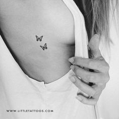 a woman's chest with a small butterfly tattoo on the left side of her stomach