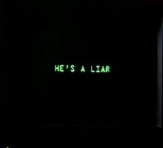 there is a neon sign that says he's a liar in the dark room