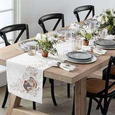 the table is set with black chairs and plates