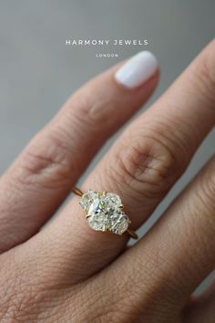 a woman's hand with a diamond ring on her finger, showing the center stone