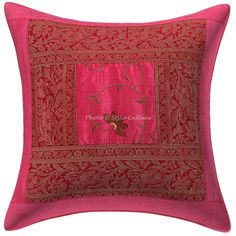 a pink and red pillow with an embroidered design on it