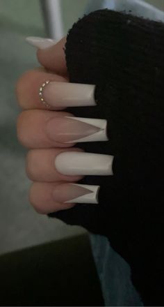 a woman's hand with some white nails on it