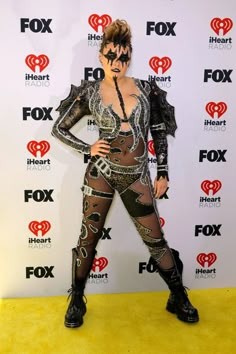 a woman in black and silver outfit standing on yellow carpet