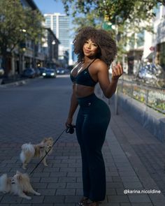 a woman walking two small dogs on a leash