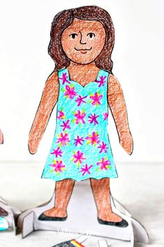 a paper doll is standing on a scale with scissors and crayons next to it