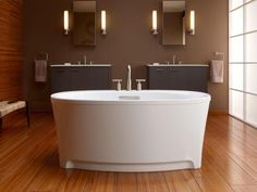 a large white bath tub sitting on top of a wooden floor