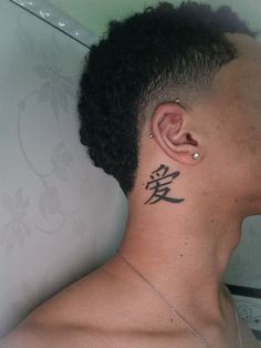 a man with a tattoo on his neck and behind his ear is looking to the side