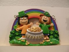 a couple of figurines sitting on top of a table next to a pot of gold coins