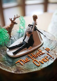 a wedding cake with a bride and groom figurine on top, sitting on a surfboard