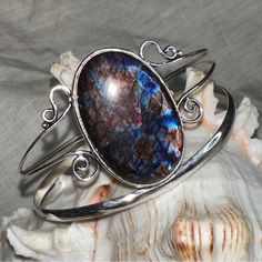 Artisan Designed & Handcrafted Aurora Borealis Blue Flash Labradorite Gemstone Handcrafted Cuff * Flashes Of Fire: Red, Blue, Purple And Gold * Circumference On Cuff Is 7.5-8.5” With 1” Adjustable Spacing * Hand Crafted 925 Sterling Silver Simulated The Flashes In The Aurora Borealis Labradorite Is A Member Of The Feldspar Family And Is Treasured For Its Remarkable Play Of Color. The Flashes Of Color, A Phenomenon Called Labradorescence. The Stone, Usually Gray-Green, Dark Gray, Black, Or Grayis Unique Oval Gemstone Cuff Bracelet, Unique Handmade Blue Bangle, Unique Oval Cuff Bracelet For Gift, Bohemian Oval Gemstone Cuff Bracelet, Artisan Handmade Blue Bangle, Unique Handmade Oval Cuff Bracelet, Unique Labradorite Cuff Bracelet As Gift, Unique Handmade Labradorite Cuff Bracelet, Unique Blue Oval Cuff Bracelet