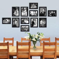 a dining room table with chairs and pictures on the wall above it that have family photos