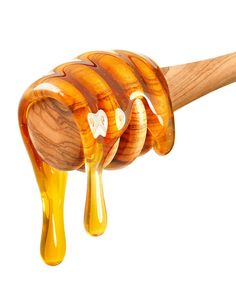 a honey dripping from a wooden spoon