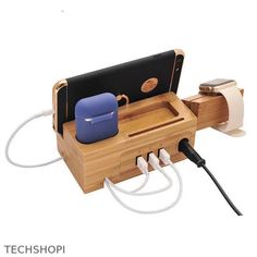 an electronic device charging in a wooden holder with cords and plugs attached to it