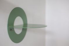 a glass shelf mounted to the side of a wall with a circular design on it