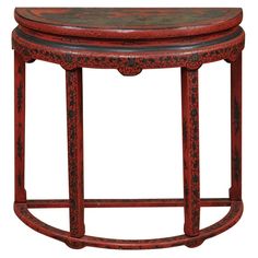 a red wooden stool with an ornate design on the top and bottom, sitting against a white background