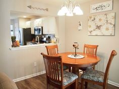 a dinning room table with four chairs and a kitchen in the backround