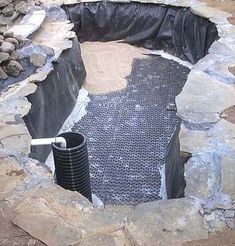 a hole in the ground that has been dug into some rocks and is filled with water