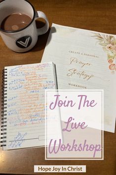 a cup of coffee sitting on top of a wooden table next to a notepad