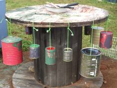 an outdoor table made out of barrels and tin cans