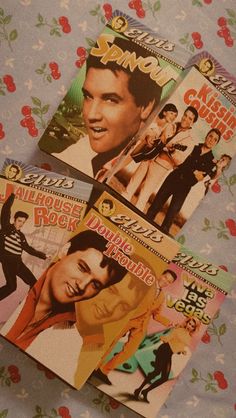 four elvis presley magazines laying on a floral print tablecloth with the covers pulled down