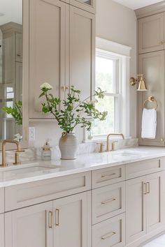 a large bathroom with marble counter tops and gold faucets