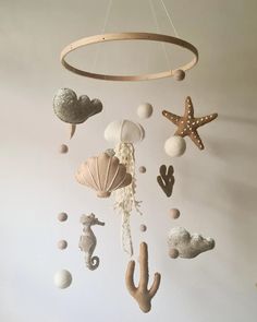 a mobile with sea animals and shells hanging from it's sides in a room