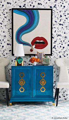 a blue cabinet with two white chairs and a painting on the wall above it that says instagram