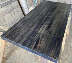 a wooden table sitting on top of a pile of pallet wood next to another piece of furniture