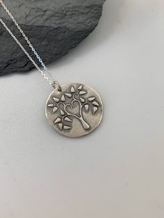 This unique Tree of Life handmade embossed round pendant has been entirely handmade using .999 fine silver. It has been cut from fine silver precious metal clay, textured, fired and oxidized. The pendant hangs from a sterling silver diamond cut cable chain. This fine silver pendant features an embossed Tree of Life image on one side of the pendant and is reversible to a tiny leaves embossed pattern on the reverse side. Pendant size: approximately 3/4 x 3/4 inches Chain length: adjustable at 16 a Layered Necklaces Boho, Moon Necklace Silver, Silver Bar Necklace, Metal Clay Jewelry, Layered Necklaces Silver, Pendant Necklace Silver, Precious Metal Clay, Unique Trees, Charm Necklace Silver