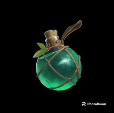 a green glass ornament with a gold crown on it's head, hanging from a wire