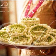 a woman holding a platter filled with white and green flowers on top of it