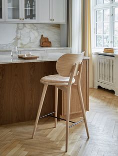 a wooden chair sitting on top of a hard wood floor next to a kitchen counter