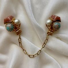 "A wonderful pair of vintage inspired sweater clips from repurposed vintage unsigned costume earrings, found with missing clips.   Stones are pink and turquoise gold glitter matrix Lucite cabochons with faux pears in gold tone settings.  Each earring is about 1.18\" across. Settings and chains are gold or silver tone base metal.   Chains are 3-4\" long. Clips are new; they are cushioned and safe for most fabrics. if you have a pair of old screw back or clip on earrings, I can make them into swea Sweater Clips, Original Jewelry Design, Dress Clips, Sweater Clip, Vintage Jewelry Necklace, Costume Earrings, Cultured Pearl Necklace, Repurposed Vintage, Original Jewelry